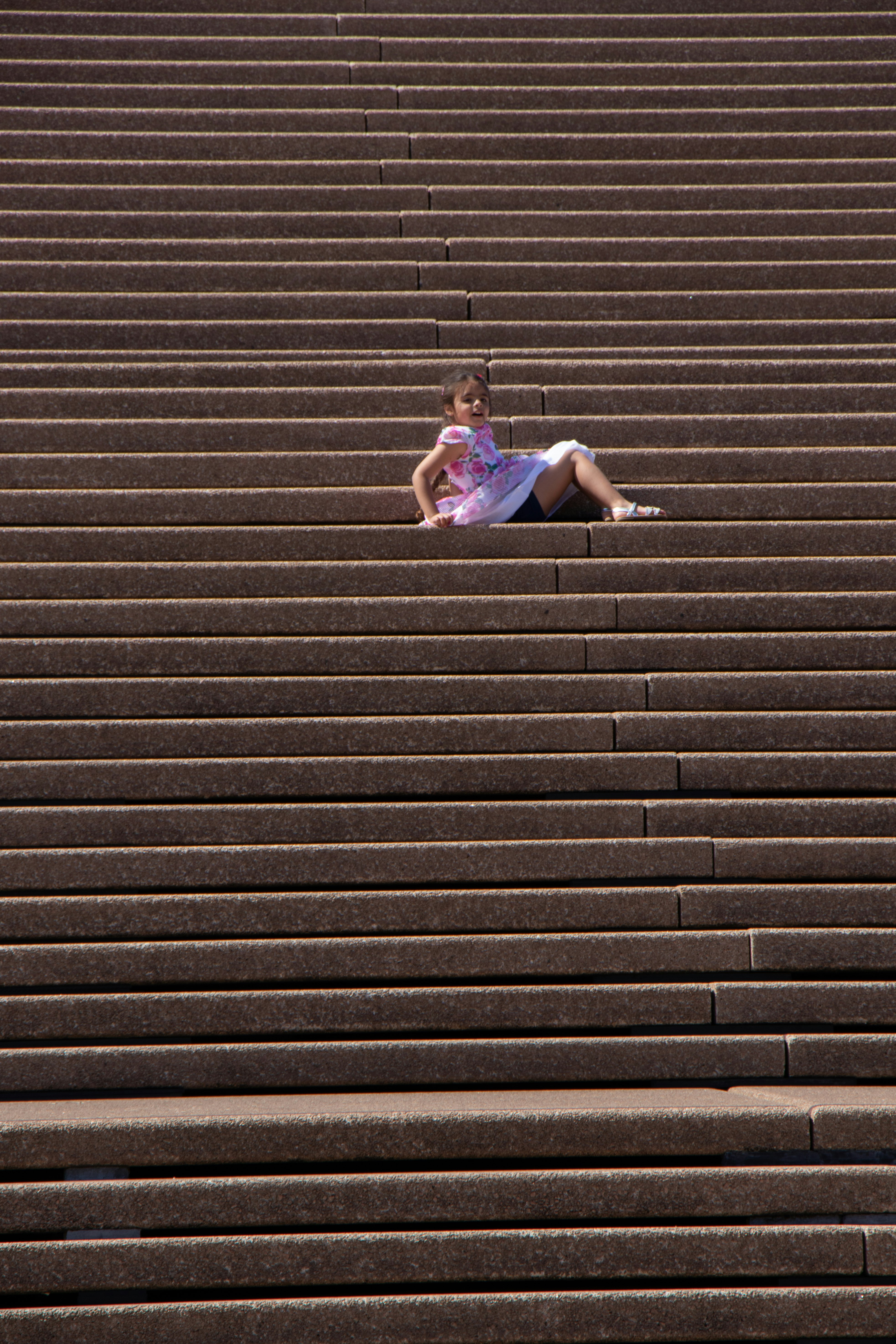 girl in purple dress sitting on stairs